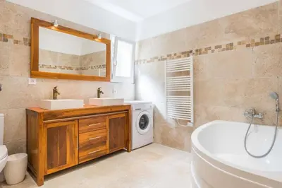 a bathroom with a sink and a washing machine at Mas des Genêts in Manosque