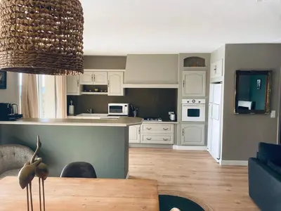 a kitchen and living room with a dining table at Hôtel le Jas de Joucas in Joucas