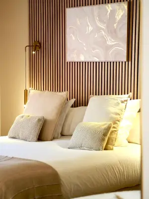 a bed with white pillows and a picture on the wall at Hôtel le Jas de Joucas in Joucas