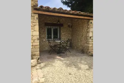 a patio with a table and chairs in a stone building at Cabanon de charme en plein coeur des vignes in Pertuis