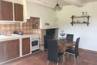 a kitchen with a table and chairs in a kitchen at Cabanon de charme en plein coeur des vignes in Pertuis