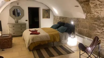 a bedroom with a bed and a dresser and a mirror at la villageoise, chambre troglodyte pitoresque au cœur du village in Rognes