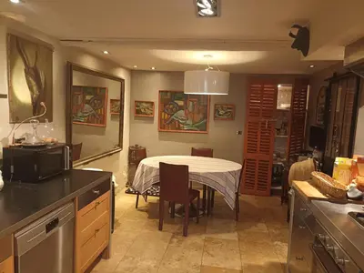 a kitchen and dining room with a table and a kitchen at la villageoise, chambre troglodyte pitoresque au cœur du village in Rognes