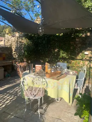 a table and chairs under an umbrella on a patio at la villageoise, chambre troglodyte pitoresque au cœur du village in Rognes