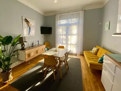 a living room with a table and a yellow couch at Villa Suzanne - Lambesc centre in Lambesc