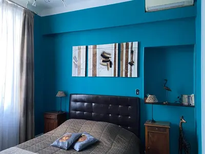 a bedroom with blue walls and a bed at Villa Suzanne - Lambesc centre in Lambesc