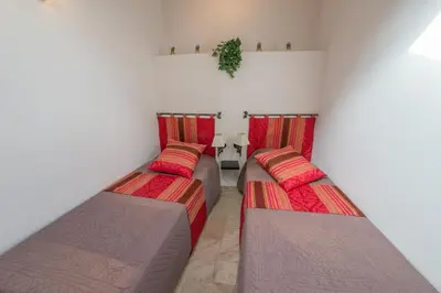 a room with two beds and a table at La Treille et L'Impasse in Ansouis