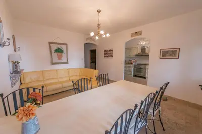 a dining room and living room with a table and chairs at La Treille et L'Impasse in Ansouis