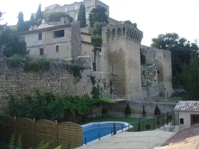 a castle with a swimming pool in front of it at La Treille et L'Impasse in Ansouis