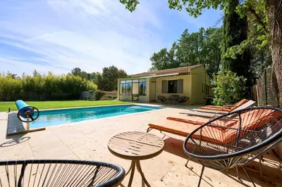 a patio with chairs and a swimming pool at La Velleronnaise in Velleron