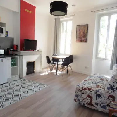 a living room with a fireplace and a table and chairs at Villa Zola in Aix-en-Provence