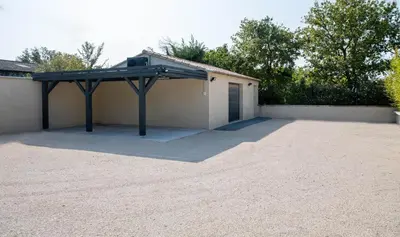 a building with a garage with a roof at VILLA PALMA & SPA in LʼIsle-sur-la-Sorgue