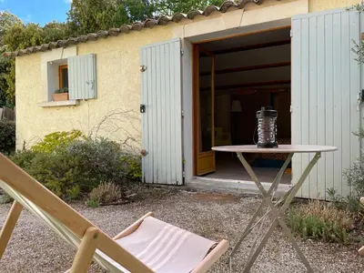 a table and a chair in front of a building at Studio Idéal pour des moments d'exceptions in Cabrières-dʼAvignon