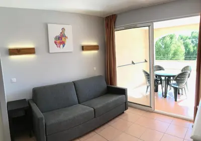 a living room with a couch and a table at Studio sur le Domaine du Golf de Pont Royal in Mallemort