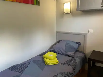 a bed with a yellow bag sitting on top of it at Studio sur le Domaine du Golf de Pont Royal in Mallemort