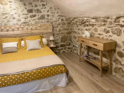 a bedroom with a bed and a wooden desk at L'Atelier de Marie in Eyguières
