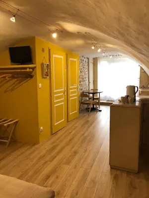 a living room with yellow doors and a table at L'Atelier de Marie in Eyguières