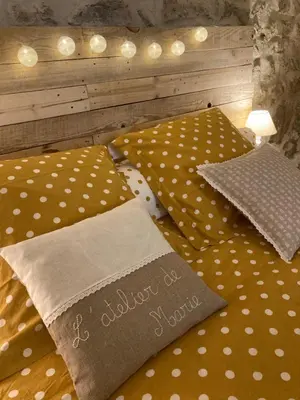 a bed with polka dot sheets and pillows on it at L'Atelier de Marie in Eyguières