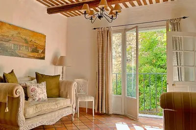 a living room with a couch and a sliding glass door at La Marisol in LʼIsle-sur-la-Sorgue