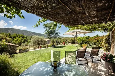 a patio with a table and two chairs and an umbrella at Chez Suzanne in Bonnieux