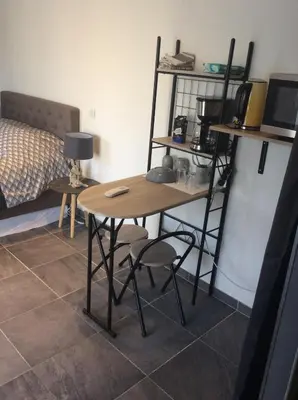 a table and chairs in a room with a bed at Ogooué Studio in Carpentras
