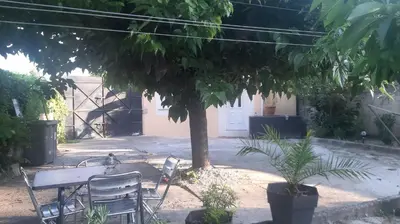 a table and chairs under a tree in a yard at Ogooué Studio in Carpentras