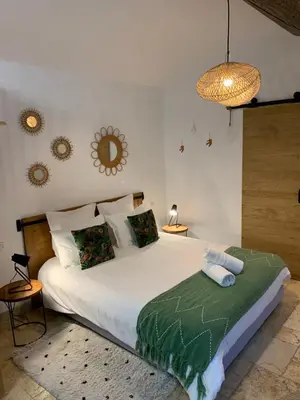 a bedroom with a large white bed and a chandelier at Mazet LEAJO in Eygalières