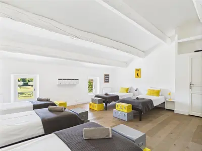 a white room with beds and couches in it at Magnifique Mas Provençal avec Piscine à Eygalières - 19 Couchages, 8 Chambres, Billard, et Plus ! - FR-1-599-3 in Eygalières