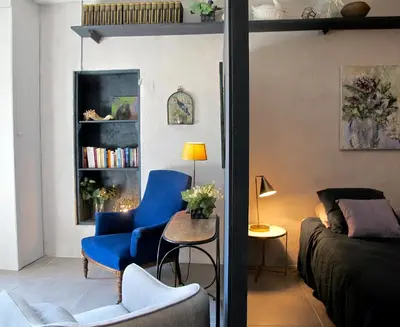 a living room with a blue chair and a couch at les Lauriers in Caromb
