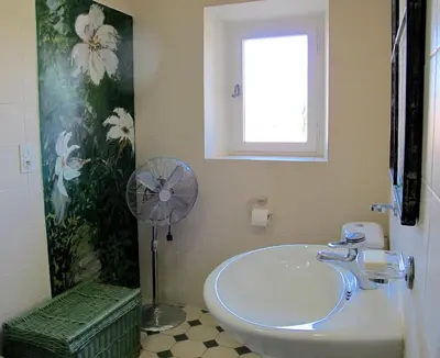 a bathroom with a white sink and a fan at les Lauriers in Caromb