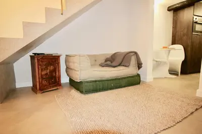 a couch sitting in a living room with a staircase at Le Madeleine (duplex) in Aix-en-Provence