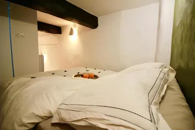 a bed with white pillows in a room at Le Madeleine (duplex) in Aix-en-Provence