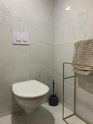 a white bathroom with a toilet and a towel at Le Madeleine (duplex) in Aix-en-Provence