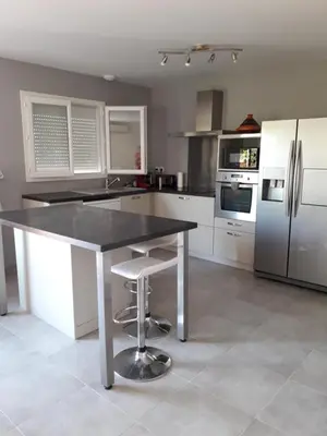 a kitchen with a black counter and white appliances at Villa au pied du Ventoux in Mormoiron