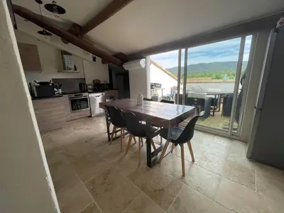 a kitchen with a table and chairs and a large window at Appartement de charme Sud Luberon classé 4 étoiles in Puyvert