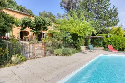 a swimming pool in front of a house with a fence at Mas de Bacalan in Mormoiron