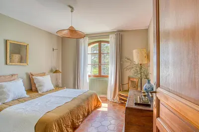 a bedroom with a large bed and a window at Mas de Bacalan in Mormoiron