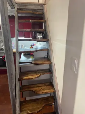 a ladder with wooden steps in a room at Studio cosy dans le centre-ville historique in LʼIsle-sur-la-Sorgue
