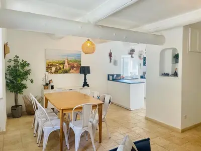 a dining room with a wooden table and white chairs at VILLA BEL - Entre paradis et vignes in Ménerbes