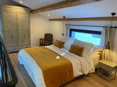 a bedroom with a large bed and a window at Le Vallon des Pins in La Cride