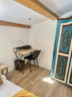 a bedroom with a desk and a table with a chair at Le Vallon des Pins in La Cride
