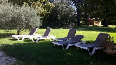 three lounge chairs sitting in the grass in a yard at Chambres d'hôtes Le Vignoble in Cucuron