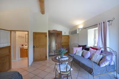 a living room with a blue couch and a table at Chambres d'hôtes Le Vignoble in Cucuron