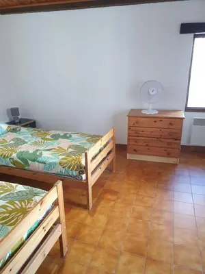 a room with two beds and a wooden dresser at Charmante maison de village au cœur du Luberon in Pierrevert