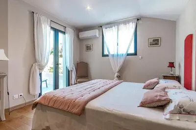 a bedroom with a large bed and a large window at La Verdière - Contemporary house with garden and private pool in LʼIsle-sur-la-Sorgue