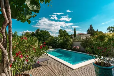 a swimming pool in a garden with flowers at La Verdière - Contemporary house with garden and private pool in LʼIsle-sur-la-Sorgue