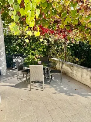 a table and chairs sitting under a tree at La Verdière - Contemporary house with garden and private pool in LʼIsle-sur-la-Sorgue