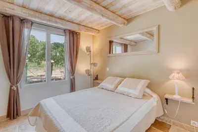 a bedroom with a bed and a window at Le JARDIN DES DELIS gite NEUF avec piscine bio UV in Saint-Saturnin-les-Apt
