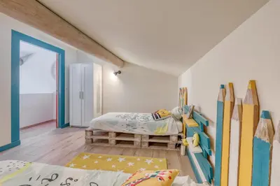 a bedroom with a bed and surfboards on the wall at Le JARDIN DES DELIS gite NEUF avec piscine bio UV in Saint-Saturnin-les-Apt