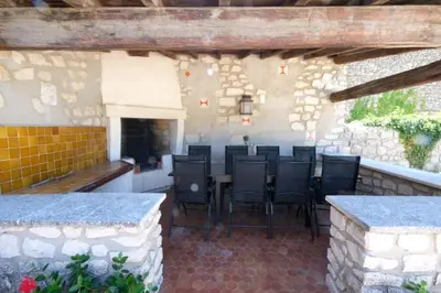 a patio with chairs and a table in a building at typical mas provençal with swimming pool in a small hamlet near mouriès in the alpilles in provence- 8 persons in Mouriès